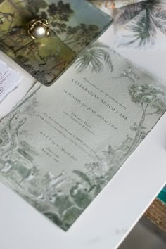 a close up of a wedding card on a table with other cards and papers around it