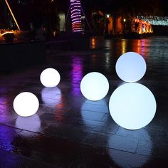 several white balls sitting on the ground at night