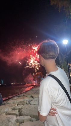 two people looking at fireworks on the water