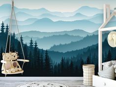 a nursery room with mountains and trees painted on the wall, including a teddy bear swing