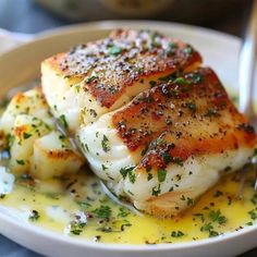 a white plate topped with fish covered in sauce