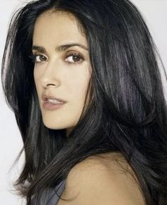 a woman with long black hair posing for the camera