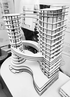 an architectural model of a building made out of multiple stacks of stacked papers on a desk