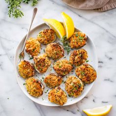 crab cakes on a plate with lemon wedges and parsley garnishes