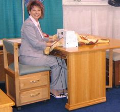 a woman sitting at a desk with a sewing machine