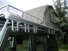 the roof rack on top of a vehicle is covered by a tarp and covers