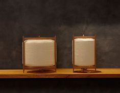 two lamps sitting on top of a wooden shelf