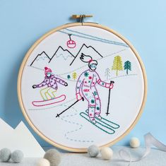 a cross stitch skiing scene with two skiers