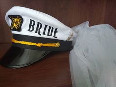 a hat that is sitting on top of a wooden table next to a white veil