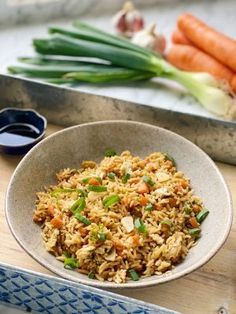 a bowl filled with rice next to carrots and celery