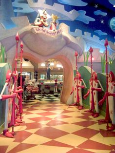 an entrance to a restaurant decorated in pink and blue with cartoon characters on the walls