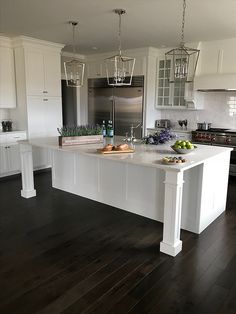 a large white kitchen with an island in the middle