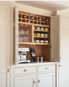 a kitchen cabinet with wine glasses and cups in it