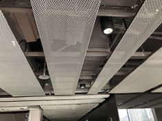 an empty office space with lots of windows and metal grates hanging from the ceiling