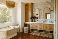 a bathroom with a tub, sink and large mirror in it's center area