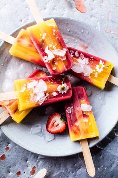 popsicles with strawberries are on a plate