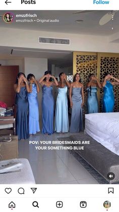 a group of women in blue dresses standing next to each other near a white bed