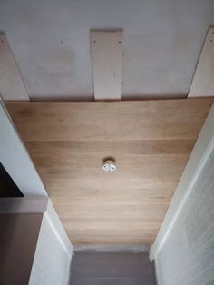 an empty room with wood paneling on the ceiling and light fixture in the corner