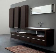 a modern bathroom with black tile flooring and white walls, along with a large mirror on the wall