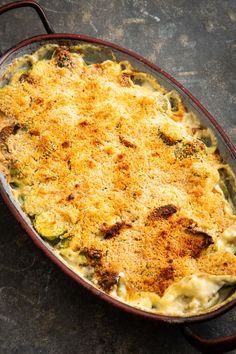 a casserole dish with cheese and broccoli in it on a table