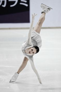 a female figure skating on the ice in a white dress and silver shoes with her arms outstretched