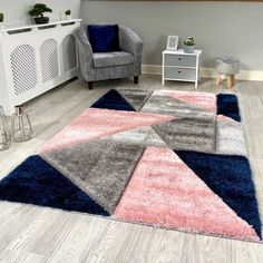 an area rug with various colors and shapes on the floor next to a gray chair