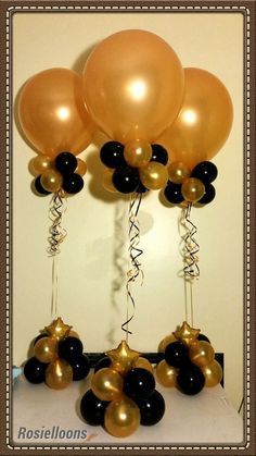 black and gold balloons are hanging from the ceiling