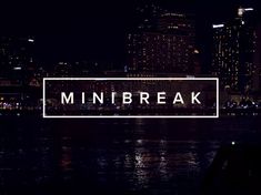 the word'mini break'is lit up in front of a cityscape