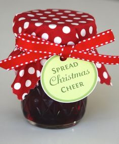 a jar filled with jam sitting on top of a white table next to a red polka dot ribbon