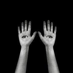 two hands reaching out towards each other with an eye in the middle and one hand on top