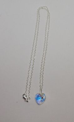 "This beautiful Swarovski Crystal Clear AB heart-shaped pendant hangs on a sterling silver chain. **AB (Aurora Borealis) is a shimmering, iridescent rainbow effect that creates an even greater sparkling quality to the base color and reflects varying colors depending on the angle of light. Pick you chain:16\" Cable, 18\" Cable, 20\" Cable, or 24\" Cable Pendant Size: 14x14mm Necklace is packaged in a white cotton-filled gift box. **Matching Earrings Available** https://www.etsy.com/SunshineJazzyJ Silver Crystal Necklace With Heart Charm Pendant, Silver Crystal Necklace With Heart Charm, Silver Crystal Necklace With Heart Pendant, Heart-shaped Sterling Silver Crystal Necklace As Gift, Silver Crystal Heart Charm Necklaces, Silver Sterling Silver Heart Crystal Necklaces, Sterling Silver Crystal Necklace With Heart Charm, Silver Crystal Necklaces With Heart Charm And Cut, Silver Crystal Heart Cut Necklace With Heart Charm