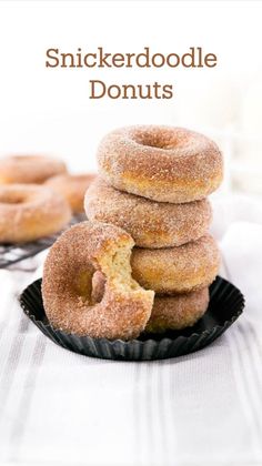 a stack of doughnuts sitting on top of a black plate next to a cooling rack