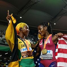 two women standing next to each other holding american flags and wearing gold medals on their shoulders