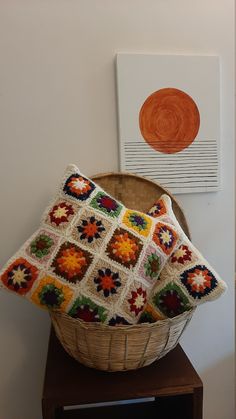 a basket that has some crochet on it and is next to a painting