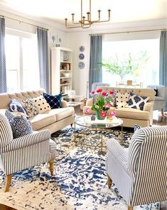 a living room with blue and white decor on the walls, couches, chairs and rugs