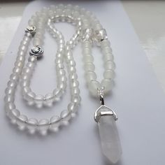 "Totally stunning handmade piece.  Unique Design for that special day.  I have used Selenite beads with accents of silver tone metal and silver foiled glass beads to add Panaz!  Finished with a lovely Quartz Crystal point.  Wonderful long Bridal necklace.  Flapper style. Have something special and different for your big day.  32\" long with 1.5\" quartz pendent.  Supplied in a lovely presentation box." Silver Healing Beaded Jewelry, Silver Healing Jewelry With 108 Beads, White Natural Stones Crystals For Spiritual Use, Elegant White Hand Wrapped Necklace, Elegant White Hand-wrapped Necklace, White Crystal Necklaces With 8mm Beads For Spiritual Use, White 8mm Beads Spiritual Crystal Necklaces, White 8mm Beads Spiritual Crystal Necklace, Elegant White Quartz Crystal Necklace