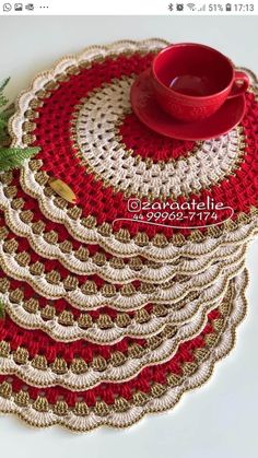 crocheted placemats are stacked on top of each other with a red cup in the middle