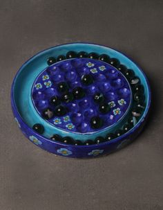 a blue bowl filled with black and white balls