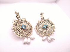 * This astonishing pair earing is a classical ornament, embellished with various elements and fine work. * The Bohemian inspired earrings feature craved motifs, Feruza stones and tinny dangling white beads. * The huge sized earrings would complete your stylish look and would add a pinch of ethnic touch to your modish look. * We assure you the High-Quality Product with On Time Delivery * White Bohemian Earrings With Intricate Design, Artisan Wedding Drop Earrings Jewelry, Traditional Chandbali Clip-on Earrings, Handmade Ornate Chandbali Jewelry, Bohemian Round Chandbalis For Pierced Ears, Bohemian Festive Pendant Earrings, Handmade Ornate Chandelier Earrings For Festive Occasions, Bohemian Drop Bridal Earrings For Festive Occasions, Bohemian Style Bridal Drop Earrings For Festive Occasions