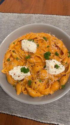 a bowl filled with pasta and cheese on top of a table