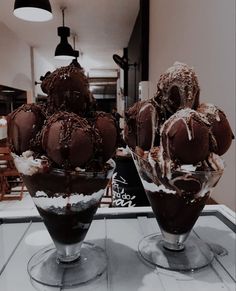 three ice cream sundaes are sitting on a table in front of a mirror