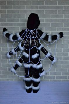 a person wearing a costume made out of fake furs and wires, standing in front of a brick wall