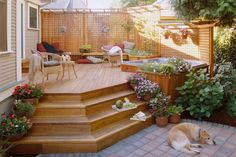 a dog laying on the ground in front of a wooden deck with hot tub and patio furniture