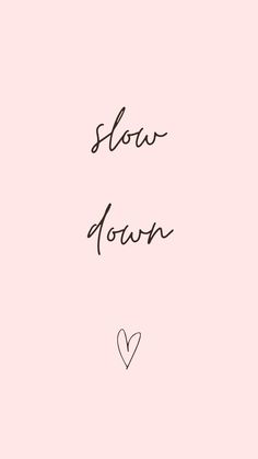 the words slow down are written in black ink on a pink background with a heart