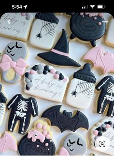 decorated cookies are arranged in the shape of bats and witches on a white tablecloth