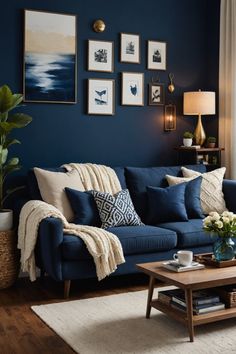 a living room with blue walls and pictures on the wall above the couch, along with a coffee table