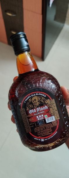 a person holding up a bottle of syrup