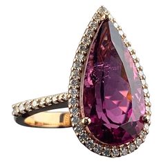 With its striking symmetry and enchanting hue, our 7.87 carat Rubelite is a masterpiece of nature. With a rich, beautifully saturated pink color and exquisite transparency, this incredible rarity is showcased in a classic setting, surrounded by 0.58 carats of White VS quality Diamonds as a halo and a pave band. The ring is made using solid 18K Rose Gold, and is currently sized at US 7 which can be resized. We offer free express shipping worldwide and we accept returns! Please feel free to message us for more information! Elegant Pear-shaped Pink Ruby Ring, Elegant Pink Pear-shaped Ruby Ring, Pave Band, Color Rosa, Quality Diamonds, Jewelry Rings Engagement, Pink Tourmaline, 18k Rose Gold, Ring Verlobung