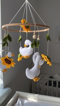 a baby crib with sunflowers and ducks hanging from it