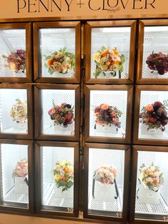 a display case filled with lots of different types of flowers in front of a window